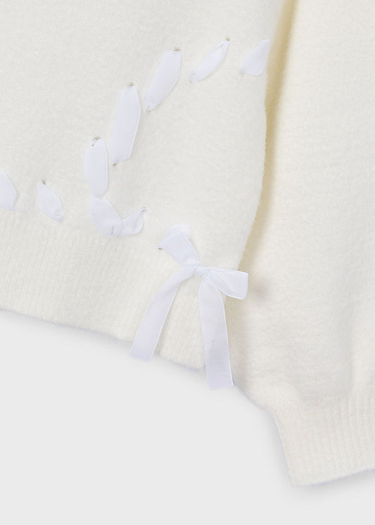 Dettaglio dei nastrini e dei fiocchi del maglione Mayoral ecrù