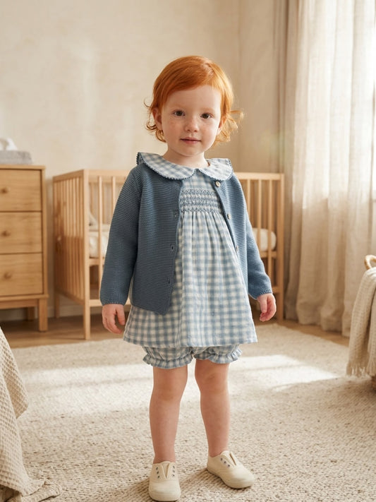 Bambina in piedi con vestina Mac Ilusion a quadretti e giacchetto blu